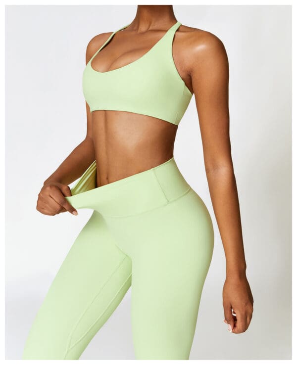 A woman in green sports bra and leggings.