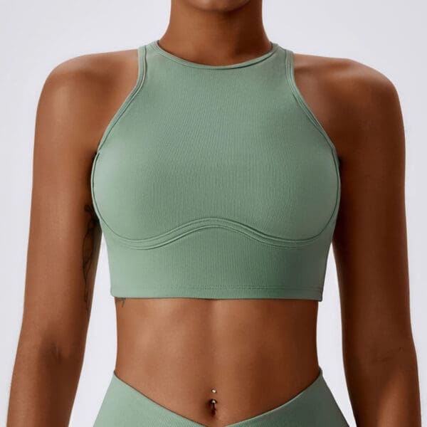 A woman wearing a green sports bra and matching bottoms.