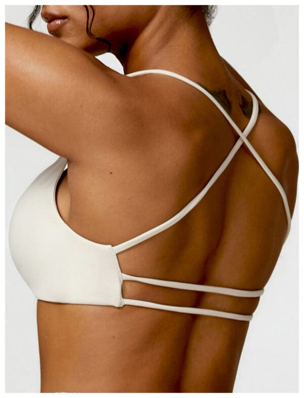 A woman wearing white lingerie with straps on her back.