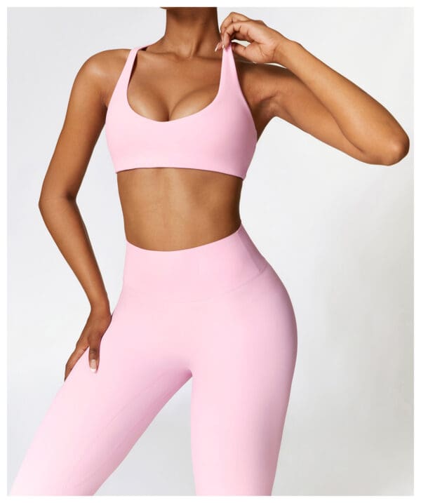 A woman in pink workout clothes posing for the camera.