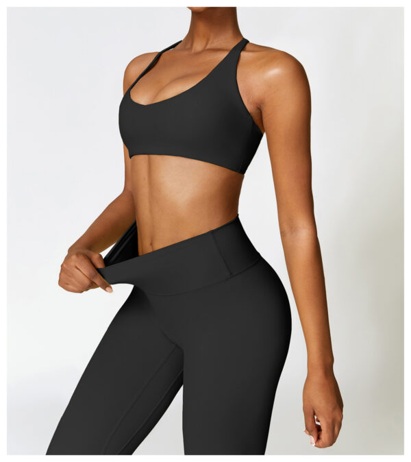 A woman in black sports bra and leggings.