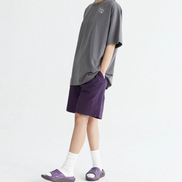 A person wearing purple shoes and shorts