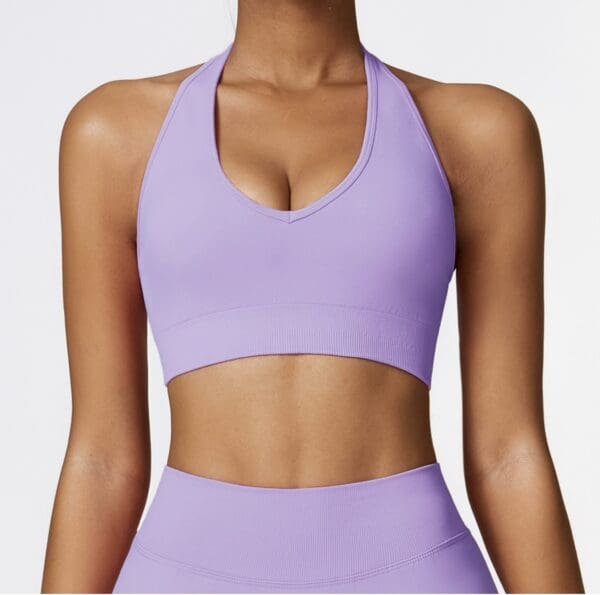 A woman wearing a purple sports bra and matching bottoms.