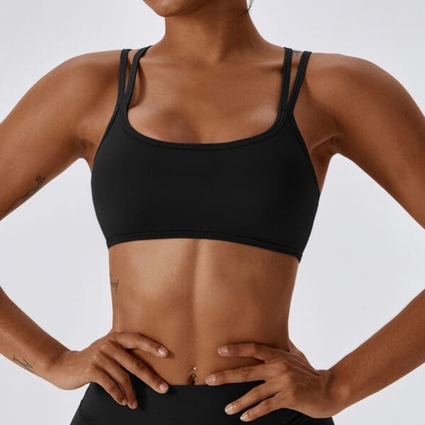 A woman in black sports bra and shorts.