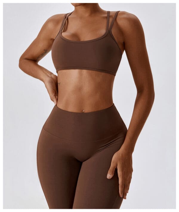 A woman in brown sports bra and leggings.