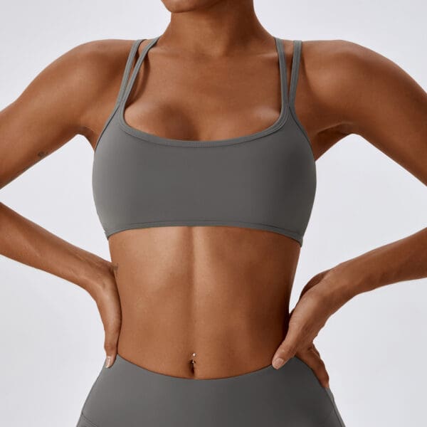 A woman in grey sports bra and shorts.