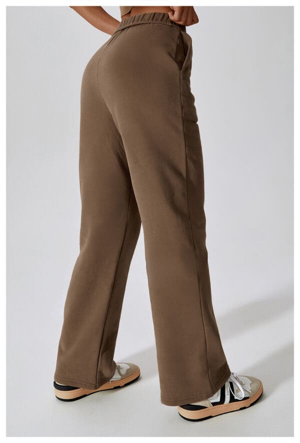 A pair of brown pants are standing up against the wall.